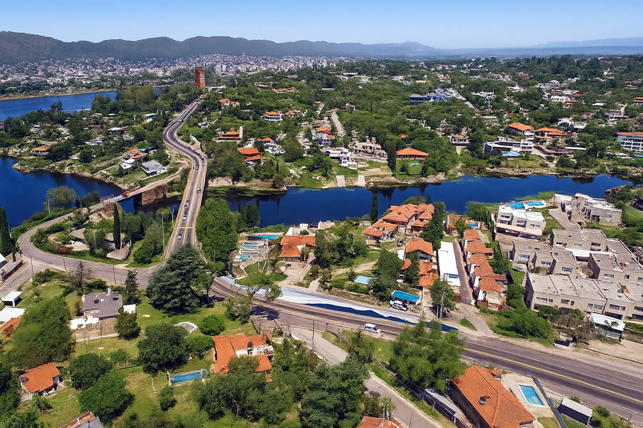 Vista panorámica del barrio Villa del Lago en Villa Carlos Paz en las Sierras de Córdoba, mostrando las montañas verdes, el lago San Roque y la arquitectura de la ciudad.